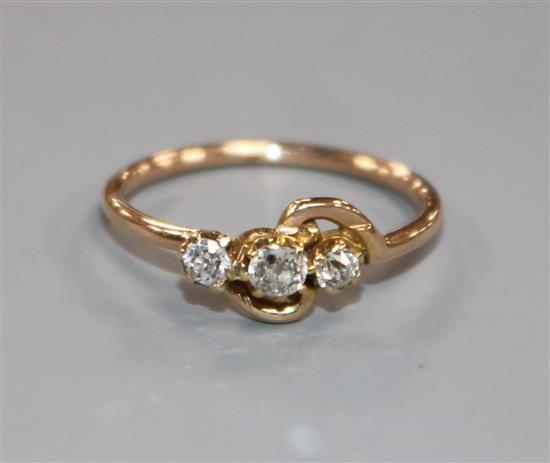 A yellow metal and three stone diamond crossover ring, size L.
